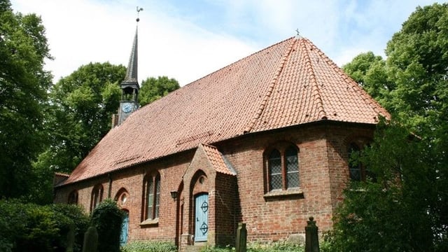 St.-Johannes-Kirche zu Seester mit Glockenturm und historischem Friedhof