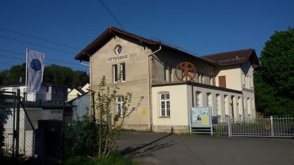Kulturbahnhof Ottensoos mit Plastik "Der Mensch tritt aus dem Rad"