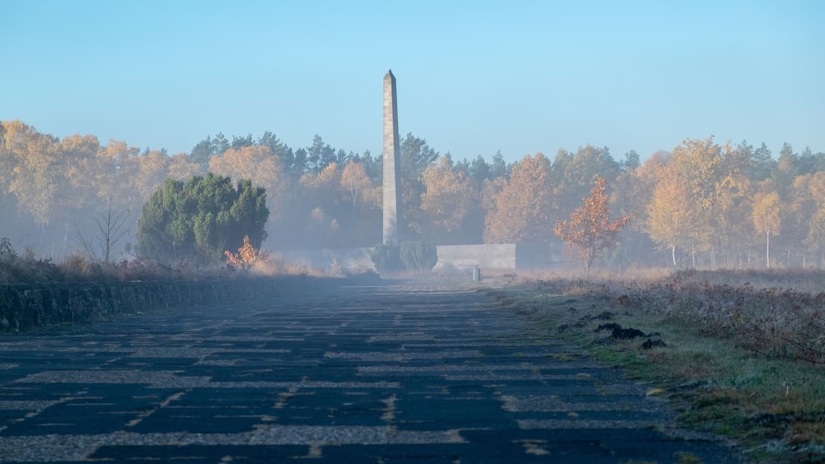 Obelisk und Inschriftenwand auf dem Gelände der Gedenkstätte Bergen-Belsen