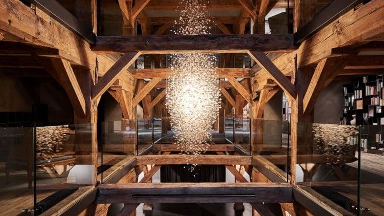 Die Lichtskulptur in der Halle ist ein Werk der Schweizer Künstlerin Madlaina Lys. 12.703 Porzellanplättchen sind auf 600 Fäden aufgezogen und verbreiten beleuchtet eine warme Atmosphäre. Das Kunstwerk hat eine Länge von 5,5 m und stellt ein verbindendes Element zwischen den Böden dar.