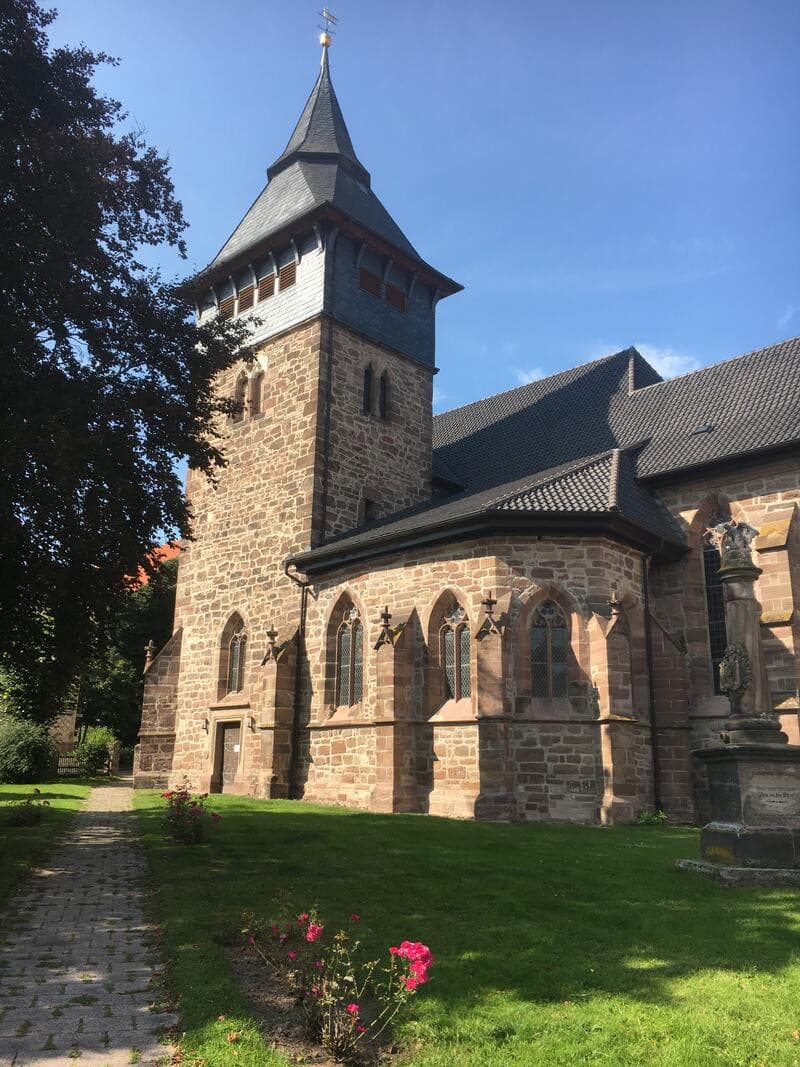 Blick von Südost auf die St. Georgs-Kapelle mit Maßwerkfenstern, Kaff- und Traufgesimsen und dem Turm (links). Rechts ist noch das Kirchenschiff zu sehen.