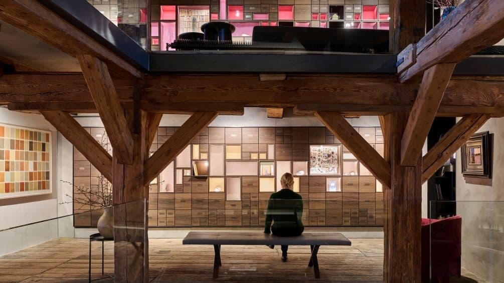 Blick über den großen Lichtraum auf die „Gelbe Galerie“ und die „Rote Galerie“. Die „Gelbe Galerie“ hat zum Thema „Natur“, die „Rote Galerie“ das Thema „Weisheit“. Vitrinen für Reflektionen auf das Leben der Verstorbenen.