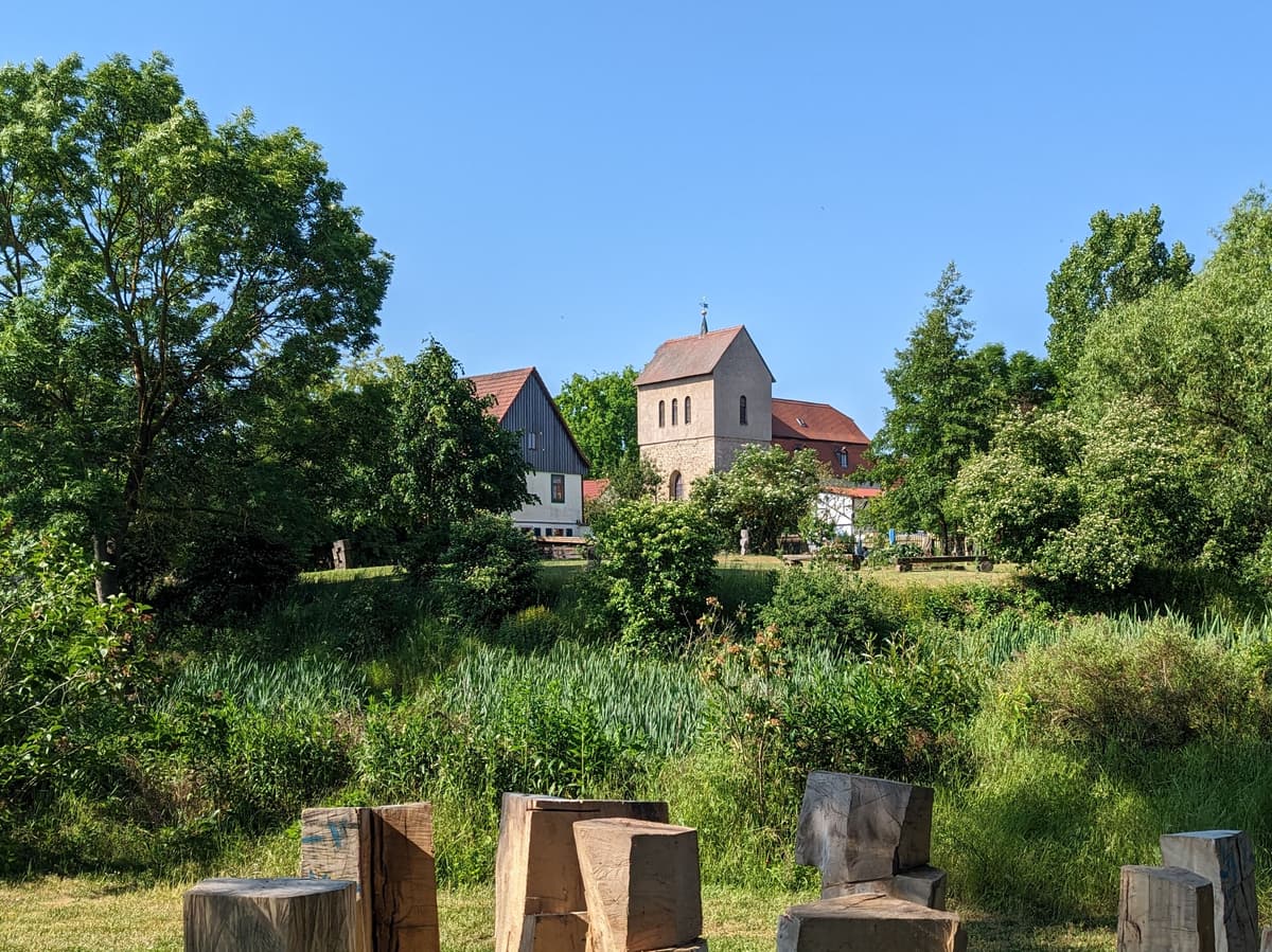 Blick auf Dorfkirche, ehem. Gesindehaus und Burggraben