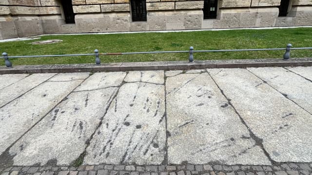 Granitplatten mit Kriegsspur („Splitterrose“) aus dem II. Weltkrieg
